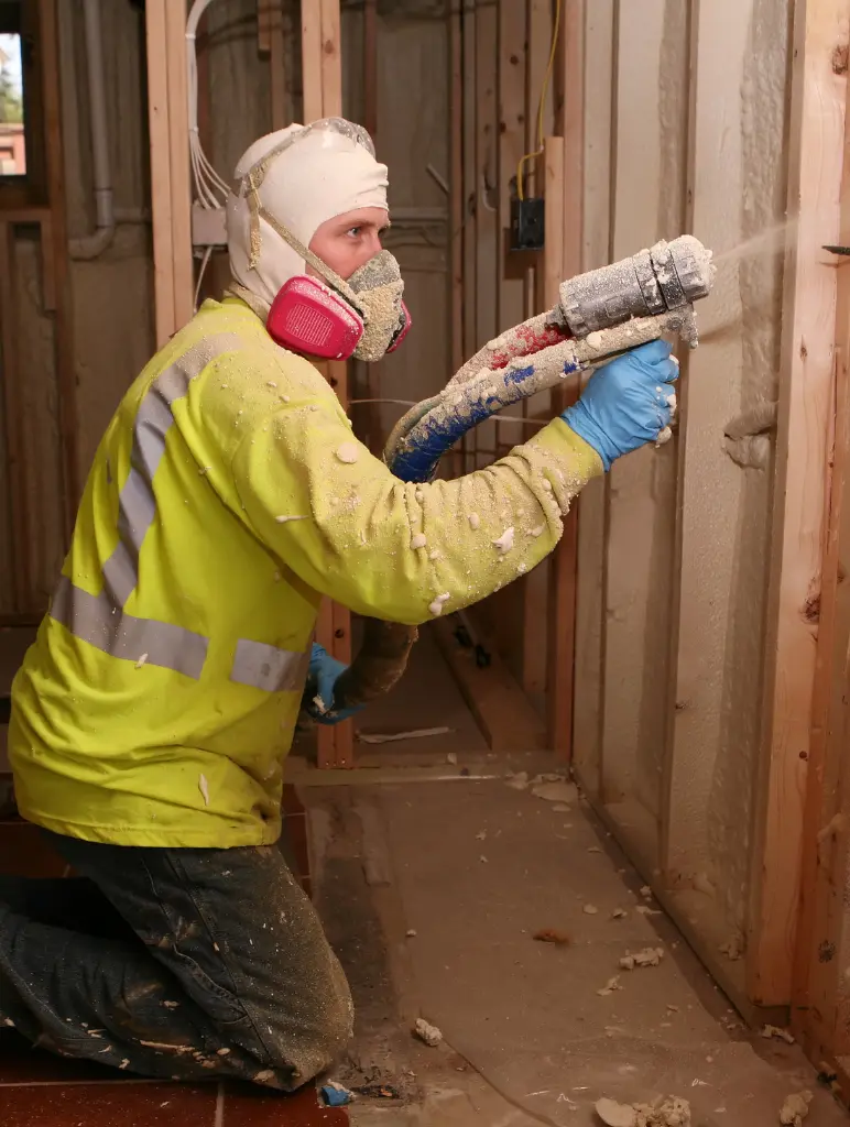 Professional contractor applying spray foam insulation in a residential building in Fort Worth.